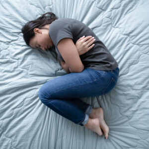 Woman lying on her bed in an article on eating disorders and depression by Greta Gleissner is the Founder of Eating Disorder Recovery Specialists