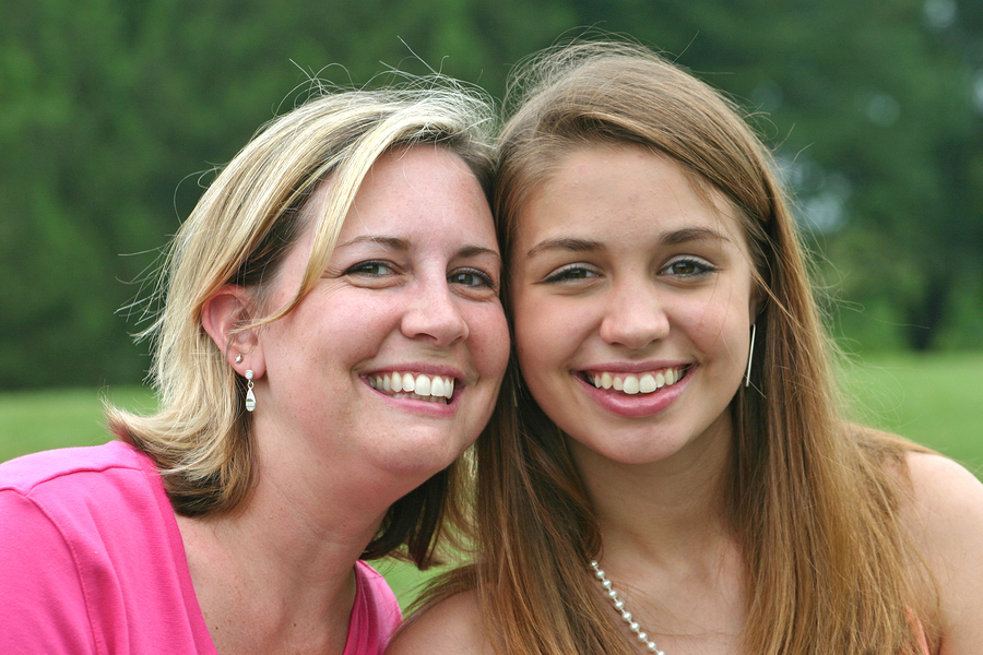 Mother side by side smiling with daughter